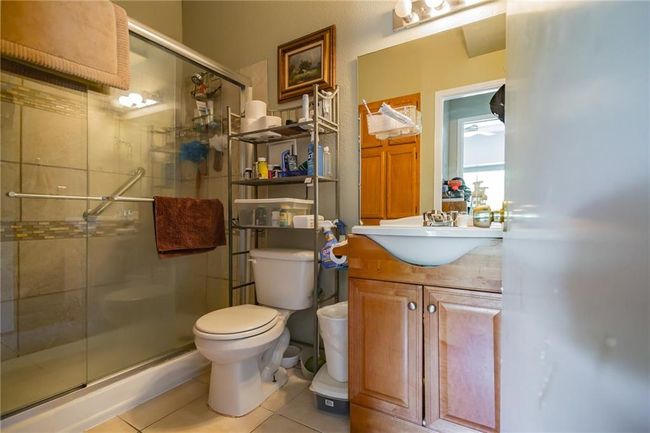 Bathroom featuring tile patterned floors, toilet, a stall shower, and vanity | Image 21
