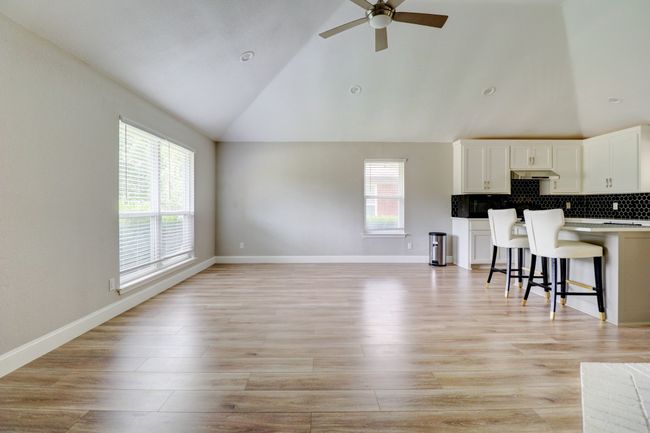 Living area with ceiling fan, high vaulted ceiling, and light wood finished floors | Image 7