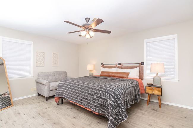 Bedroom with baseboards, a ceiling fan, wood finished floors, and multiple windows | Image 17