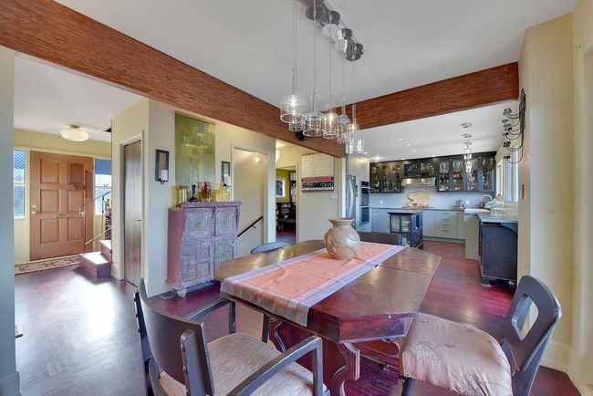 Dining space with beam ceiling, dark wood-style floors, and a chandelier | Image 10