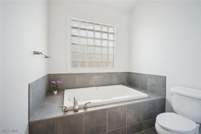 Bathroom with a bath and toilet | Image 19