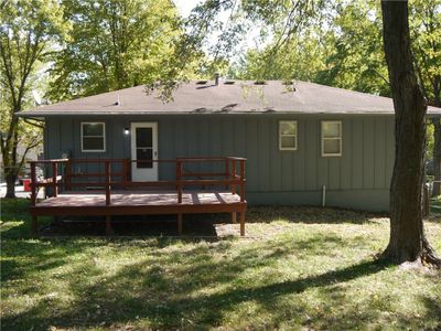 Rear view of house featuring a wooden deck and a lawn | Image 2