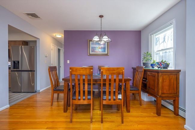 Open Dining Room with hardwood flooring, visible vents, baseboards, and an inviting chandelier | Image 8