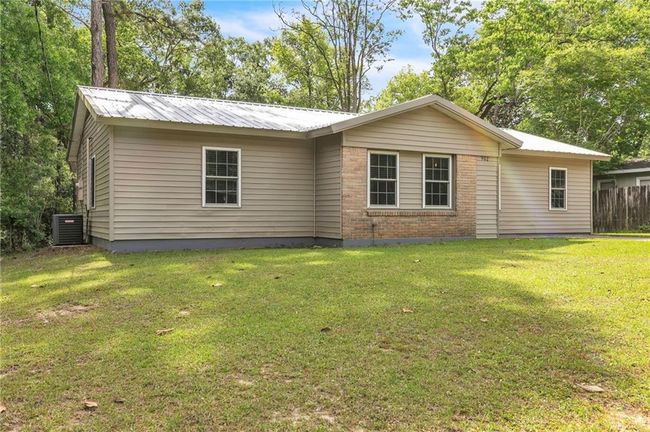 Back of property featuring a lawn, metal roof, and fence | Image 5