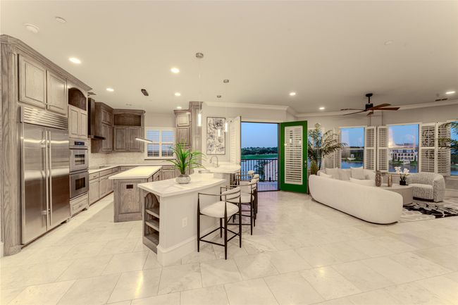Kitchen with appliances with stainless steel finishes, open shelves, ornamental molding, light countertops, and a breakfast bar area | Image 20