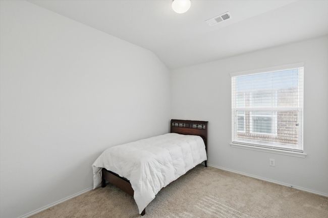 Carpeted bedroom featuring lofted ceiling, visible vents, baseboards, and multiple windows | Image 14