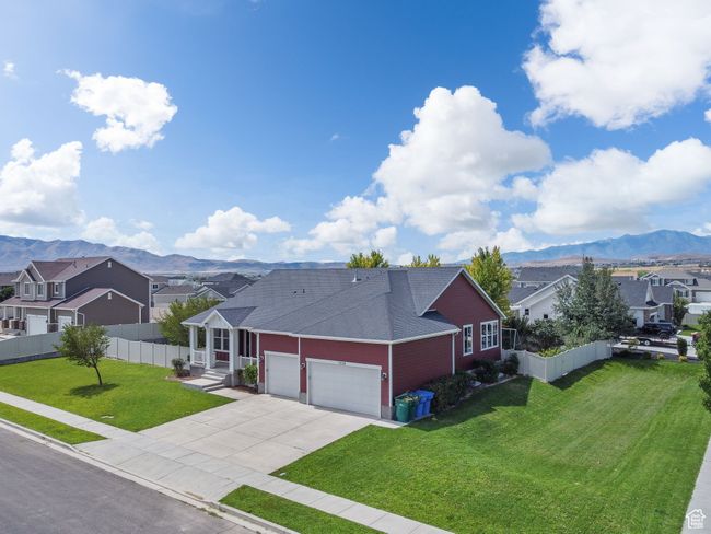 View of front of home with a residential view, a mountain view, a garage, driveway, and a shingled roof | Image 47