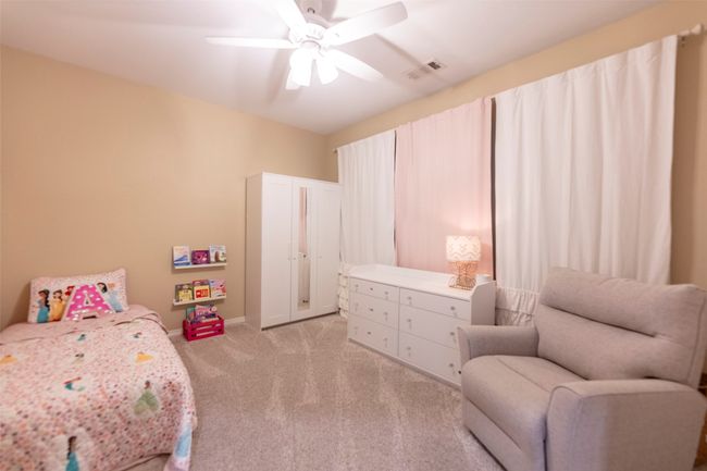 Bedroom featuring light colored carpet and ceiling fan | Image 25
