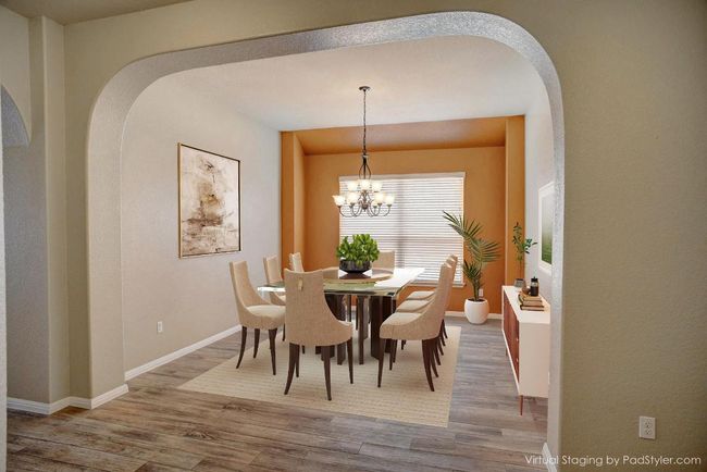 Dining space featuring arched walkways, wood finished floors, and a chandelier | Image 6