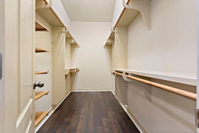 Walk in closet featuring dark wood finished floors | Image 19