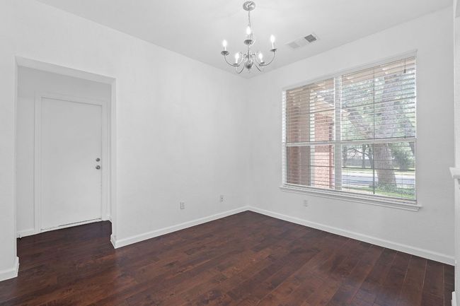Unfurnished room featuring a chandelier, dark wood-style floors, and baseboards | Image 26
