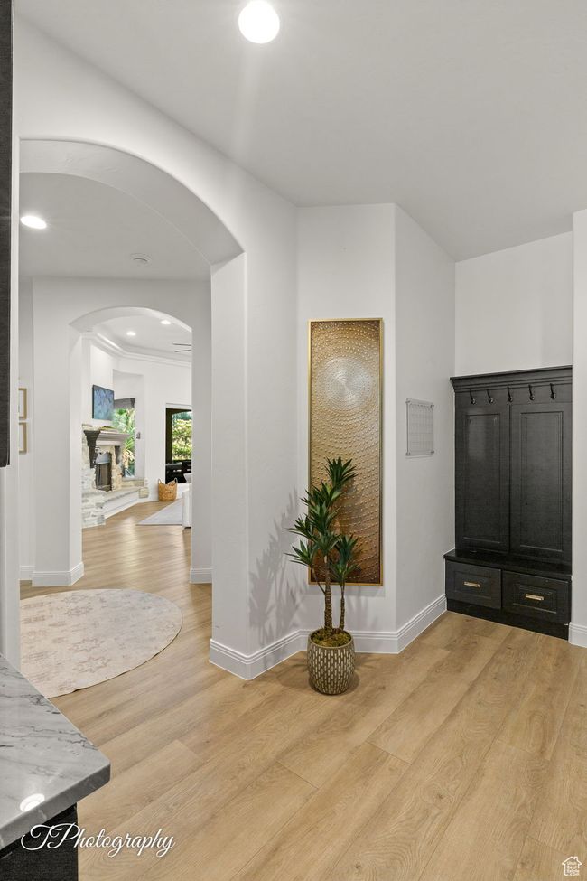Foyer entrance with arched walkways, light wood-style flooring, and baseboards | Image 14