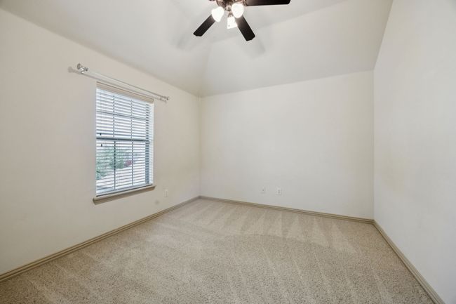 Carpeted empty room featuring ceiling fan, vaulted ceiling, and baseboards | Image 31
