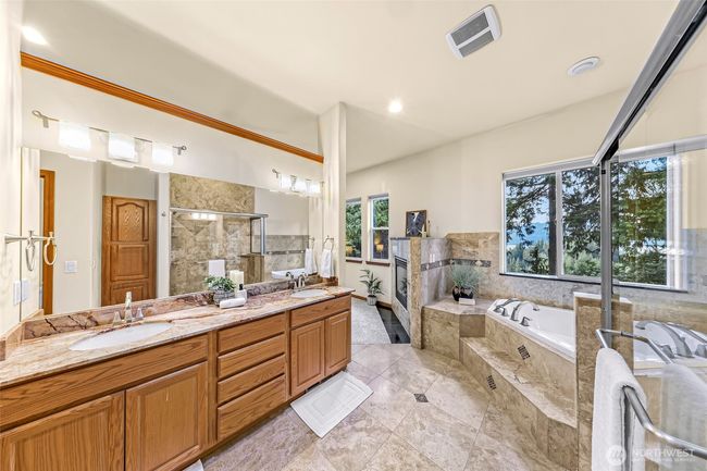 Main level primary en-suite bathroom with double sinks and a great view from the bathtub and shower of the lake. | Image 13