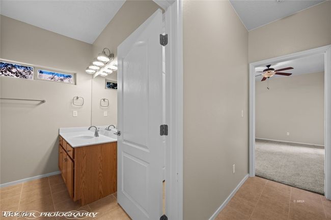 Bathroom with tile patterned floors, vanity, baseboards, and ceiling fan | Image 16