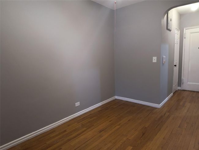 Spare room with dark wood-type flooring, baseboards, and arched walkways | Image 12