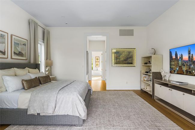 Bedroom featuring dark wood-type flooring, multiple windows, and ensuite bathroom | Image 25