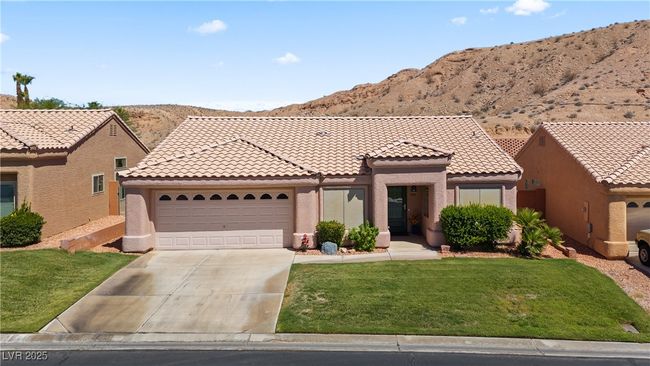 View of front of home featuring a garage, driveway, stucco siding, a front lawn, and a mountain view | Image 52