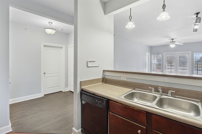 Kitchen featuring a sink, baseboards, ceiling fan, dishwasher, and dark wood-style flooring | Image 9