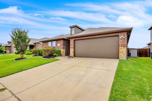 View of front of home featuring brick siding, an attached garage, driveway, roof with shingles, and stone siding | Image 4