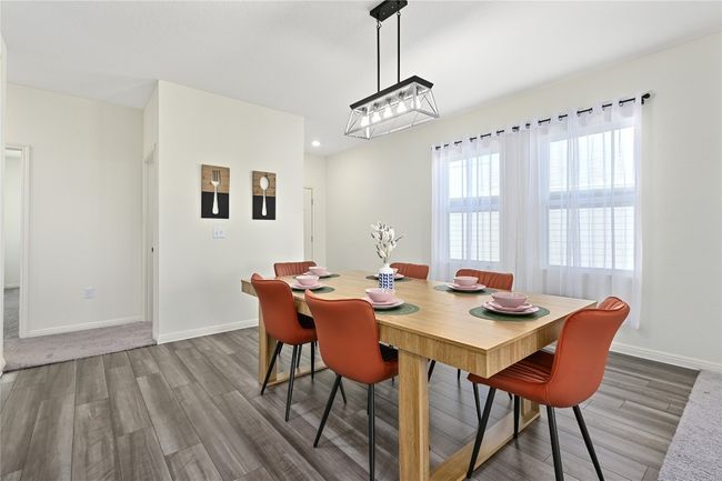 Dining area with baseboards, a notable chandelier, wood finished floors, and recessed lighting | Image 7