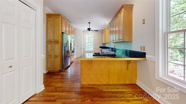 Roomy kitchen with ample storage. | Image 10