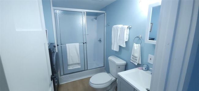Bathroom with an enclosed shower, toilet, vanity, and wood finished floors | Image 14