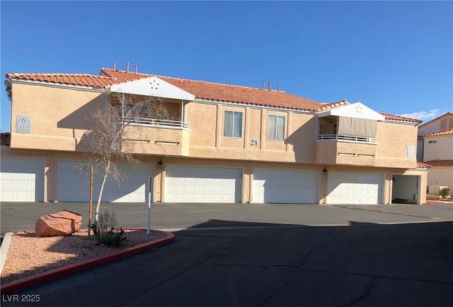 View of front facade featuring a balcony, stucco siding, a tiled roof, concrete driveway, and an attached garage | Image 42