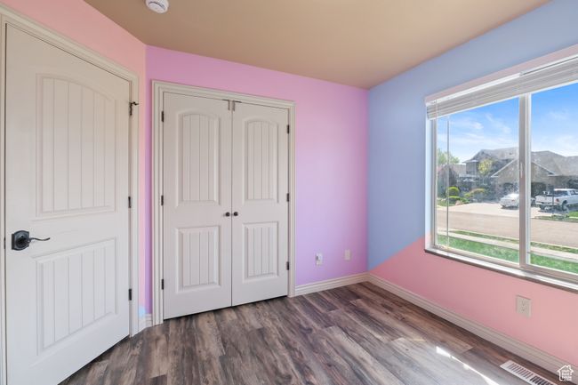 Unfurnished bedroom featuring baseboards, visible vents, wood finished floors, and a closet | Image 16