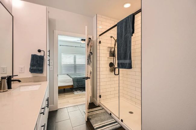 Master bath; Ensuite bathroom with a shower stall, tile patterned floors, vanity, recessed lighting, and ceiling fan | Image 17