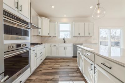 Photo is of the actual home. Be impressed with the large kitchen island & walk-in pantry! | Image 3