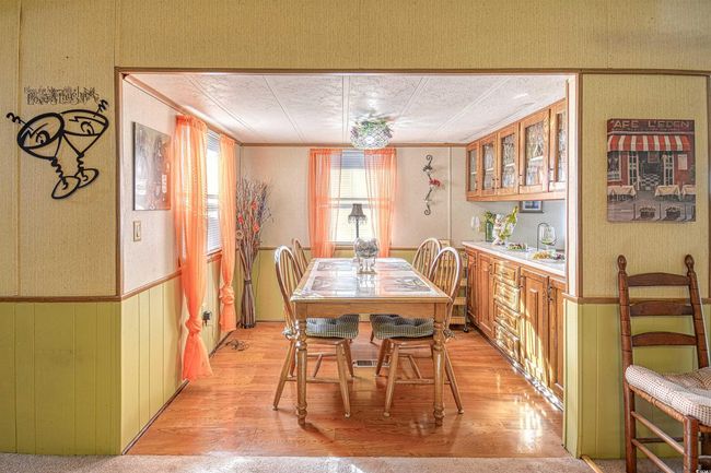 Dining room with bar area, crown molding, and light hardwood / wood-style flooring | Image 4