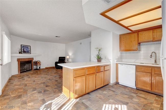 Kitchen with dishwasher, a sink, open floor plan, a peninsula, and stone finish flooring | Image 15