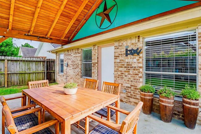This photo has been virtually enhanced to show the inviting covered patio where you'll find a perfect retreat to relax, unwind, and enjoy the outdoors in comfort. | Image 30