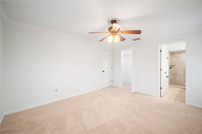 Unfurnished bedroom with light colored carpet, ornamental molding, ceiling fan, a closet, and ensuite bath | Image 13