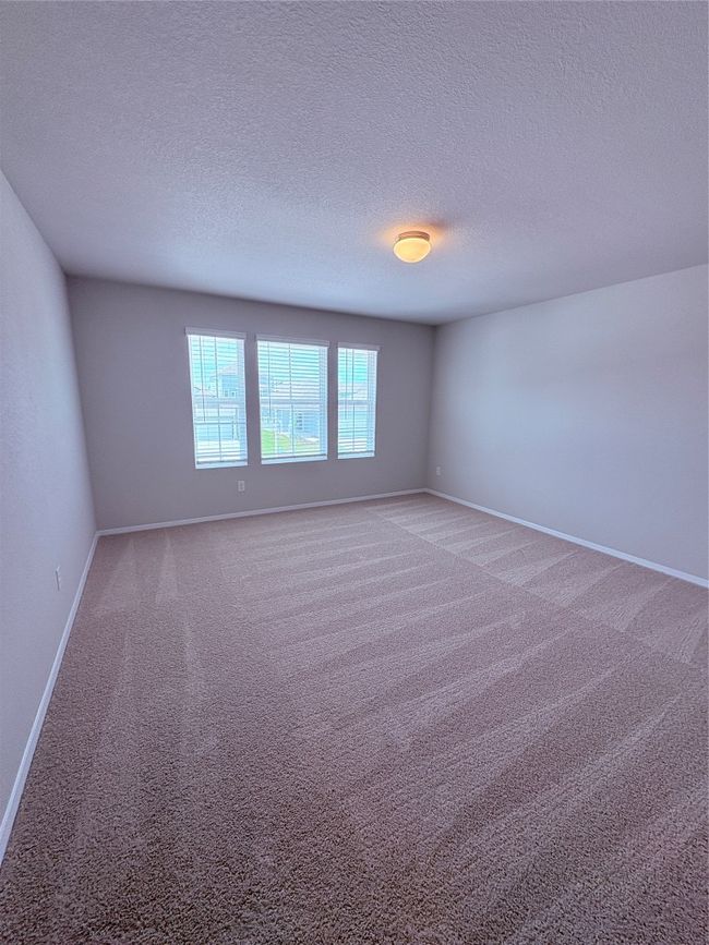 Empty room featuring baseboards, a textured ceiling, and light colored carpet | Image 28