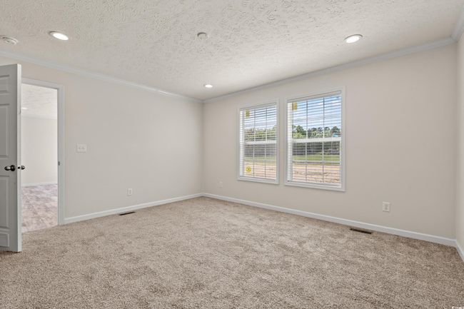 Spare room with crown molding, carpet, a textured ceiling, visible vents, and baseboards | Image 26