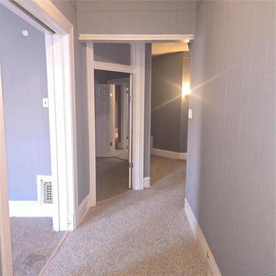 1st floor Unit Hallway featuring wood walls and carpet flooring | Image 2