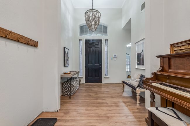 Foyer entrance featuring a chandelier, light wood finished floors, and a towering ceiling | Image 7