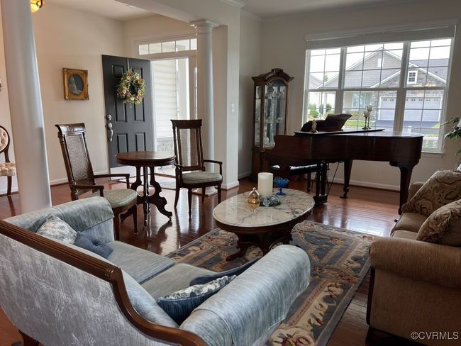 Living room featuring hardwood / wood-style flooring, crown molding, and ornate columns | Image 10
