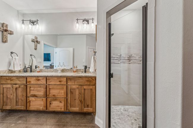Bathroom featuring a stall shower and double vanity | Image 15