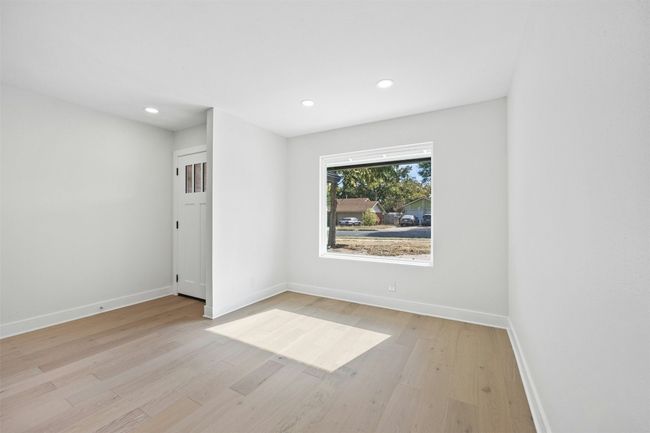 Empty room with light wood-style floors and recessed lighting | Image 12