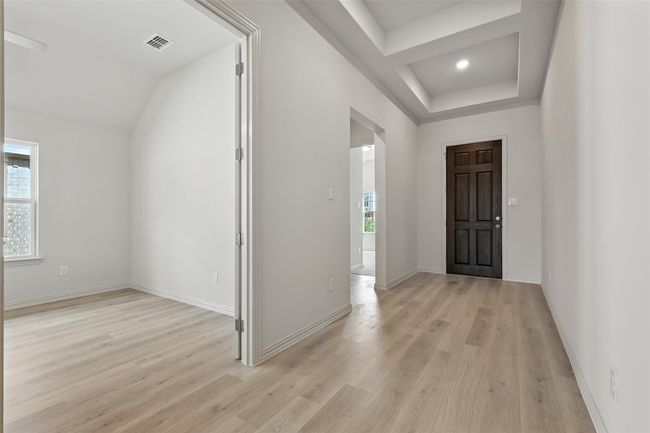 Entryway featuring light wood finished floors and a tray ceiling | Image 17