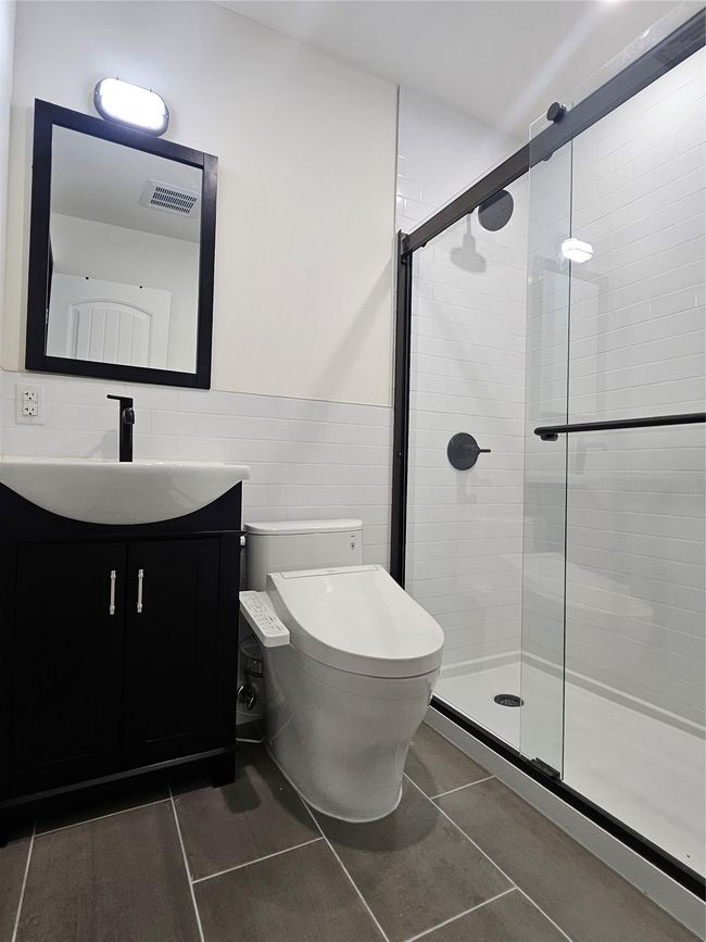 Laundry room featuring water heater, separate washer and dryer, and dark wood finished floors | Image 24