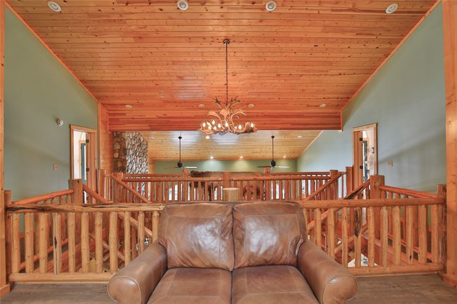 Living area with wood finished floors, high vaulted ceiling, wooden ceiling, and ceiling fan with notable chandelier | Image 37
