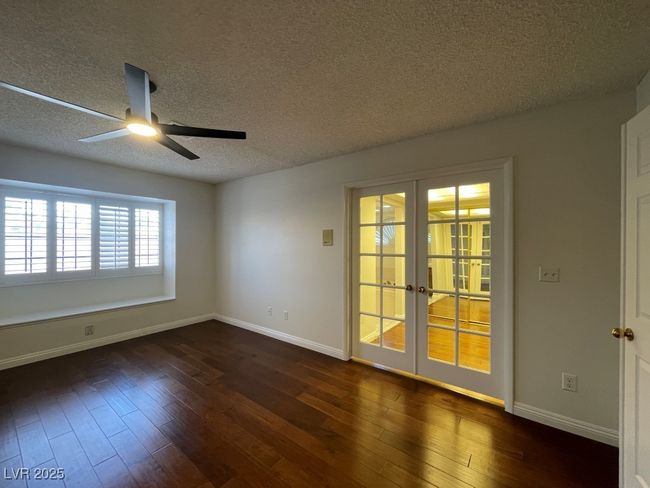 Spare room featuring french doors, a ceiling fan, dark wood-style floors, and a textured ceiling | Image 29
