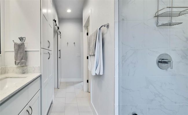 Bathroom featuring a tile shower, vanity, and recessed lighting | Image 21
