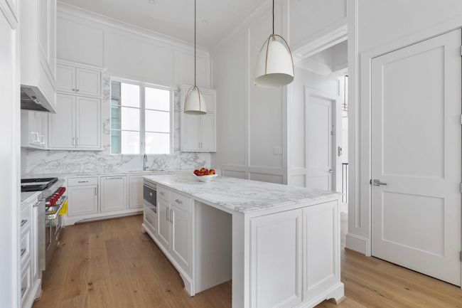 An abundance of natural light pours through expansive windows into this open kitchen enhanced by designer touches and rich architectural elements that elevate everyday living. | Image 14