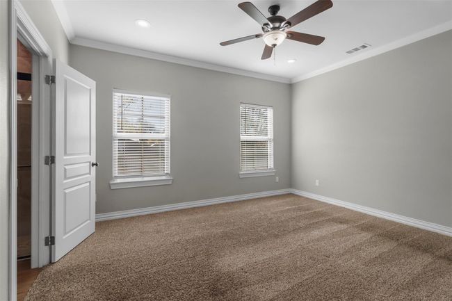 Carpeted empty room with healthy amount of natural light, ceiling fan, crown molding, and recessed lighting | Image 9