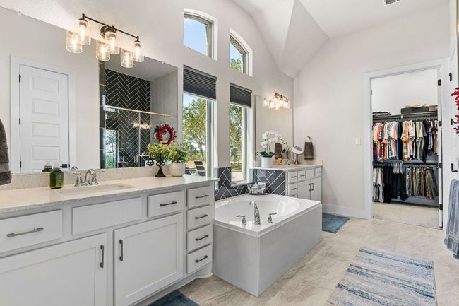 Full bathroom featuring a bath, a spacious closet, a wealth of natural light, and vanity | Image 25